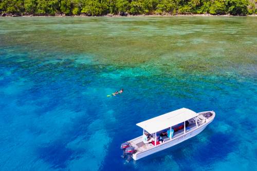 Snorkeler nearby Cove Eco Resort boat, Yeben Island, Raja Ampat